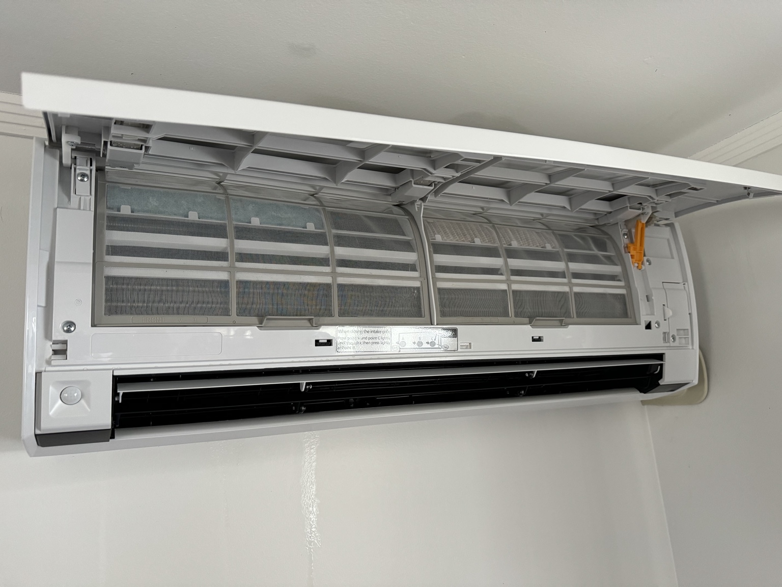 Open wall mounted heat pump with clean filters and casing